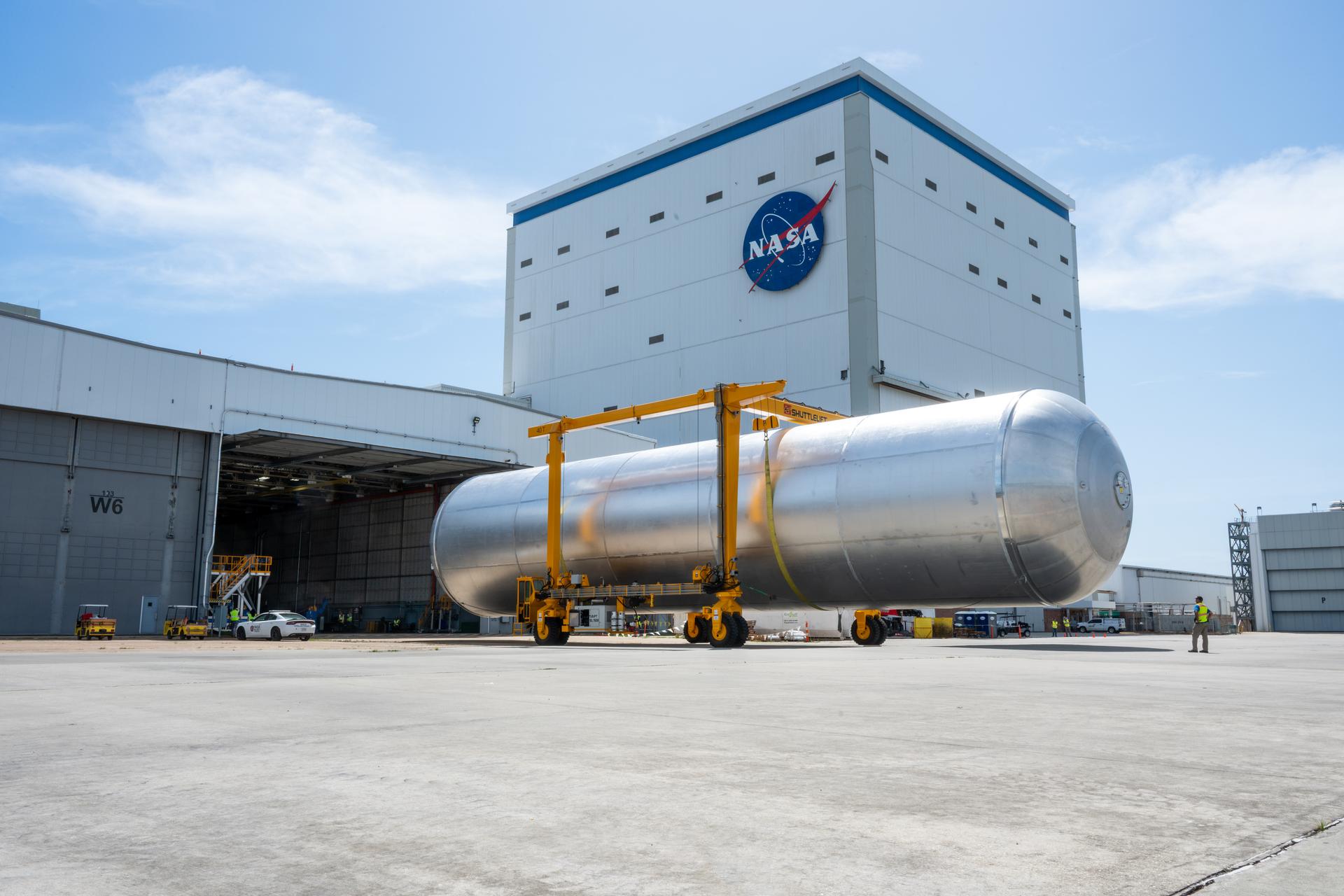 Crews at NASA’s Michoud Assembly Facility in New Orleans transport the 130-foot-tall liquid hydrogen tank from the proof testing building to the main factory on July 10. The liquid hydrogen tank will form part of the core stage for the SLS (Space Launch System) rocket for the agency’s Artemis IV mission, providing thousands of gallons of super-cold propellant to the rocket engines during launch. Soon, teams with SLS prime contractor, Boeing, will move the tank into the facility’s vertical assembly building for cleaning operations.   The liquid hydrogen propellant tank is one of five major elements that make up the 212-foot-tall SLS rocket stage. The core stage, along with its four RS-25 engines at its base, produce more than two million pounds of thrust to help launch NASA’s Orion spacecraft, astronauts, and supplies beyond Earth’s orbit and to the lunar surface for Artemis.      